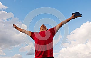 Young man staying with raised hands