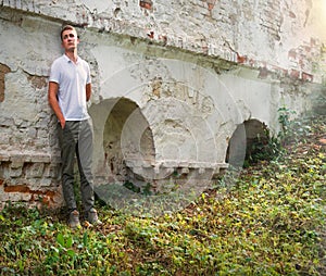 Young man staying at the wall