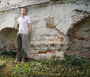 Young man staying at the wall