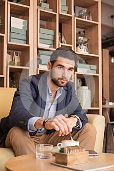 Young man stirring coffee cup indoors caffee bar