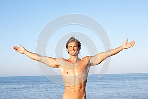 Young man stretching on beach