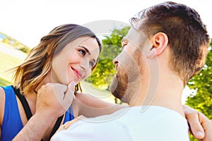 Young man stroking face of his happy girlfriend