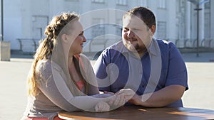 Young man stroking girlfriend hand, romantic date in outdoor cafe, closeness