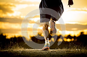 Young man strong legs off trail running at amazing summer sunset in sport and healthy lifestyle