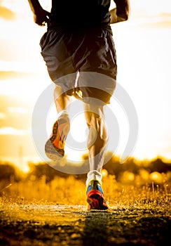 Young man strong legs off trail running at amazing summer sunset in sport and healthy lifestyle