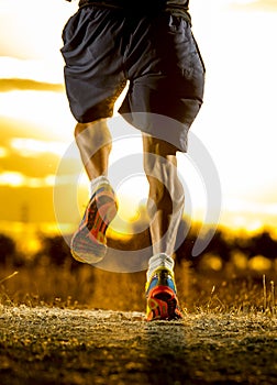 Young man strong legs off trail running at amazing summer sunset in sport and healthy lifestyle