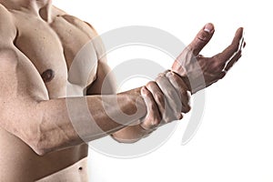 Young man with strong muscle body holding damaged wrist suffering pain in sport injury