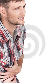 Young man with strong stomach pain isolated on white background.