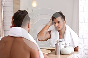 Young man with stubble ready for shaving near mirror