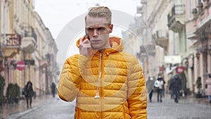 A Young Man Student talk to the Phone on the Winter Street in Europe