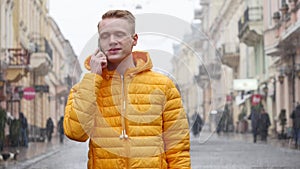 A Young Man Student talk to the Phone on the Winter Street in Europe