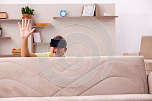 Young man student with virtual glasses at home