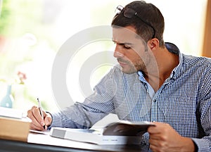 Young man or studying with books or pen for job, busy learning or writing with focus at desk. Male student or