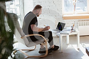 Young man studying at home during online courses for programmer, bug-tester, consulter