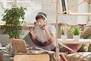 Young man studying at home during online courses for programmer, bug-tester, consulter
