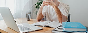 Young man studying at home and prepare for pass exam. Wide image