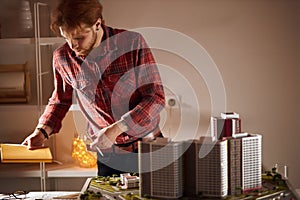 Young man in stylish checked shirt hoilding a pen