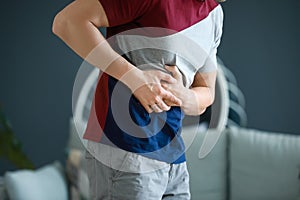 Young man suffering from abdominal pain at home