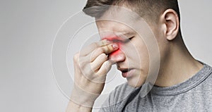 Young man suffering inflamed nose, panorama with free space