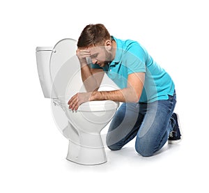 Young man suffering from nausea near toilet bowl