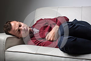 Young man suffering from severe belly pain photo