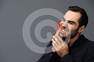 Young man suffering from toothache on background, space for text