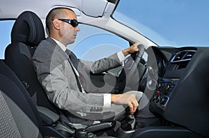 Young man in suit driving a car
