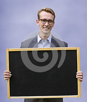 Young man in suit holding up chalkboard