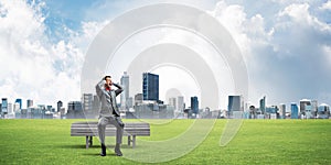 Young man in suit in park dont want to hear anything