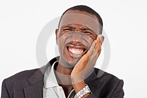 Young man in suit standing on white background, suffering