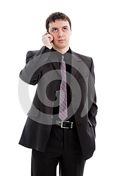 A young man in a suit, talking on the phone.