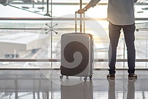 Young man with suitcase luggage in airport terminal