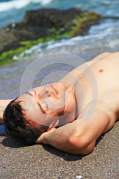 Young man sunbathing on a beach