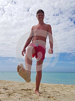 Young man sunbathing on the beach in the Caribbean sea