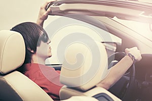 Young man in sunglasses driving convertible car