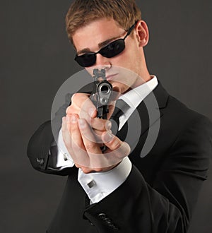 Young man with sunglasses and a gun