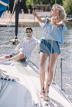 young man in sunglasses sitting and looking at beautiful girl