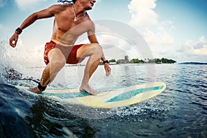 Young man surfer rides the ocean wave