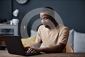 Young Man Surfing Internet On Laptop