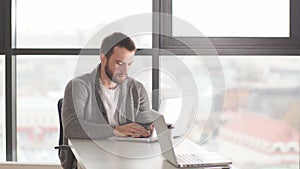 Young man surfing internet on laptop while sitting at coffee shop