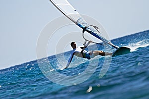 Young man surfing the wind in splashes of water