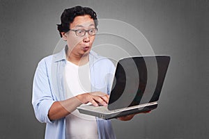 Young Man Surprised Looking at a Laptop