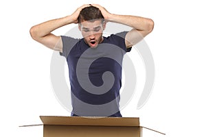 Young man surprised looking to the box. on a white background.