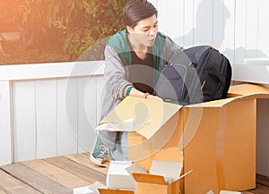 Young man surprised opening box and looking inside and unpacking the package received online shopping parcel opening boxes buying