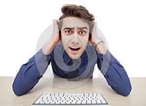 A young man is surprised while using a computer