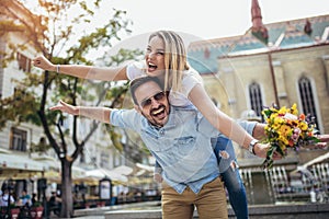 Young man surprising woman with flowers