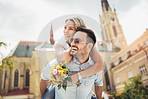 Young man surprising woman with flowers