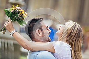Young man surprising woman with flowers