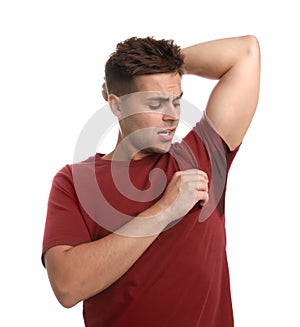 Young man with sweat stain on his clothes against background. Using deodorant