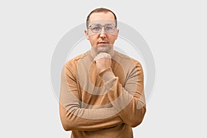 Young man in sweater looking at camera on gray background